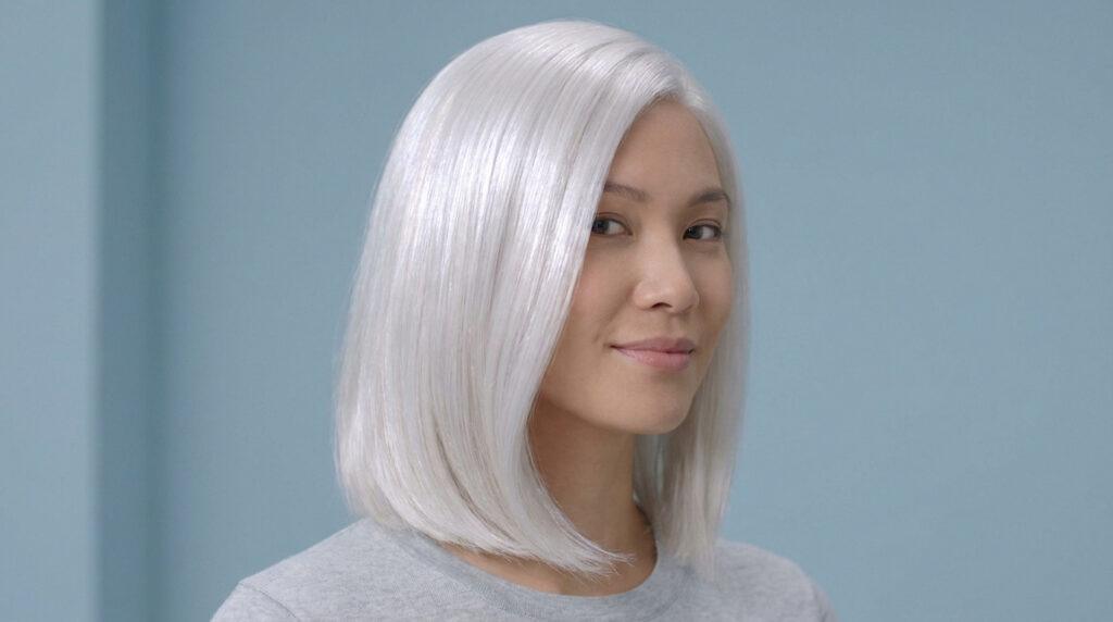 Femme aux cheveux lisses et brillants d'un blanc polaire éclatant sur fond bleu.