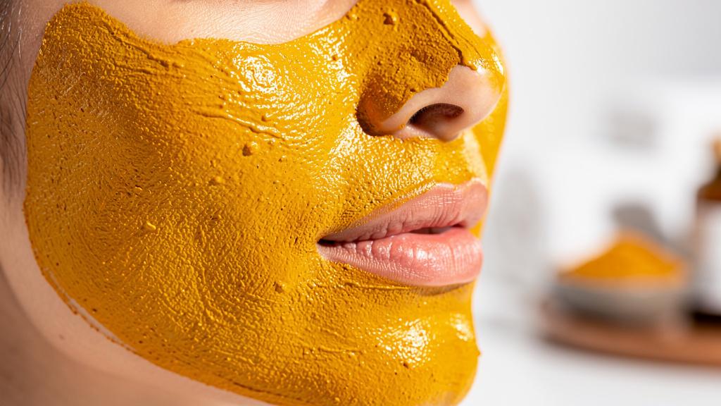 Masque visage au curcuma appliqué sur une peau