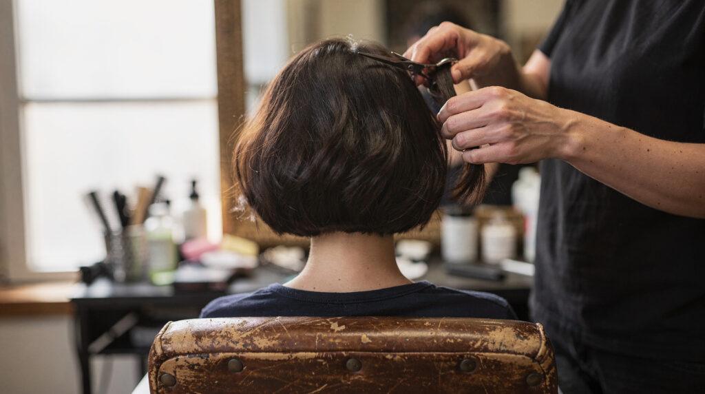Femme de 50 ans chez le coiffeur regardant sa nouvelle coupe