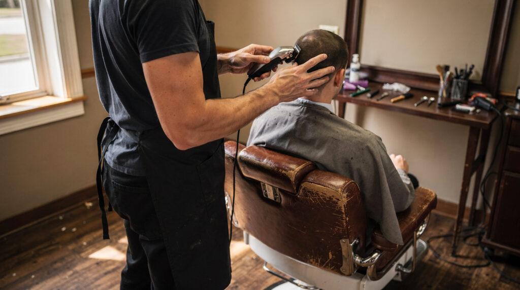 Coiffeur réalisant un dégradé fade sur un client en salon de coiffure