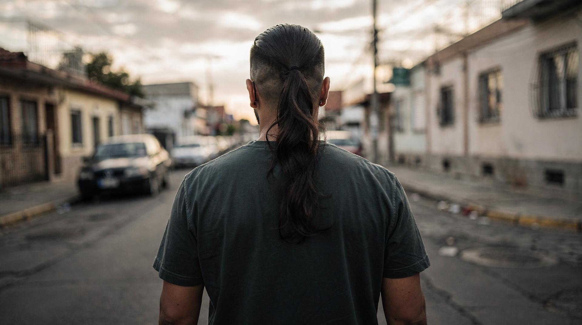 Homme de profil avec un mulet dégradé moderne en extérieur